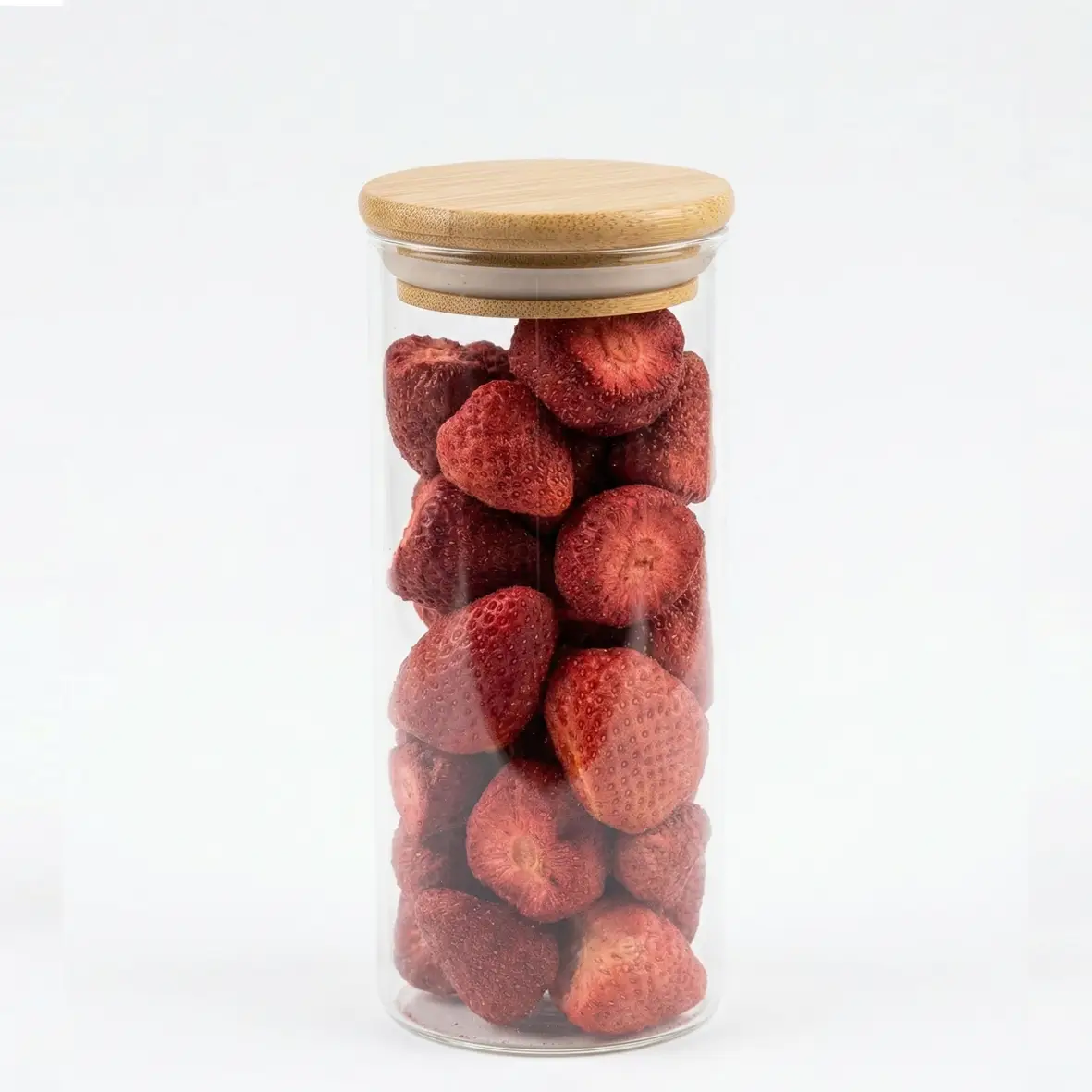Uma mão delicada polvilha pedaços de morango liofilizado Pregiato sobre uma sobremesa requintada em um prato branco minimalista. Demonstração do uso culinário do morango seco crocante em receitas gourmet e doces finos no Brasil